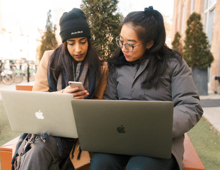 two girls sitting with their laptops - Milano Software guest blog